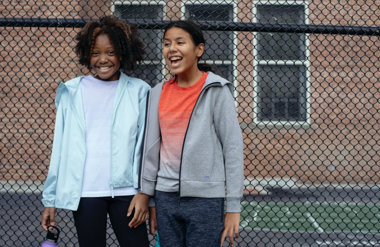 cheerful diverse schoolgirls on sports ground